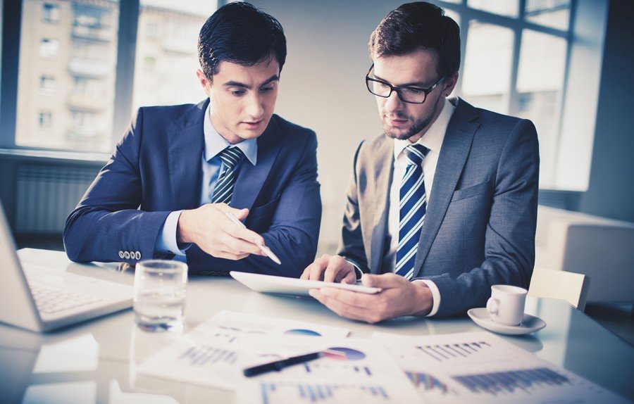 Dos hombres asesores fiscales haciendo declaraciones trimestrales y anuales