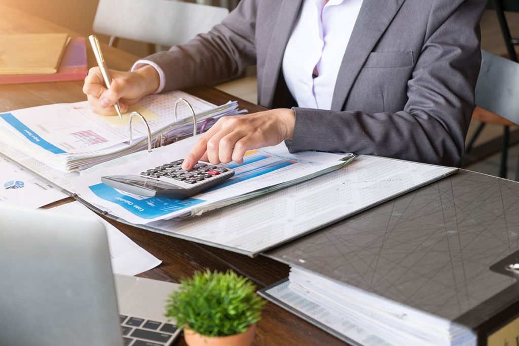 Informe con calculadora, papeles y bolígrafo para preparar la regularización con hacienda de autónomos en Barcelona